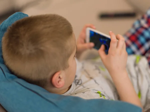 小男孩玩电子游戏在智能手机在家里 — 图库照片