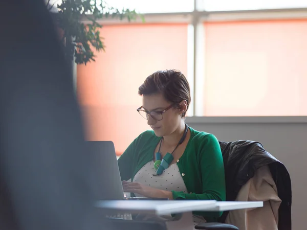コワーキングスペースでノートパソコンを使って働く若い女性起業家 — ストック写真
