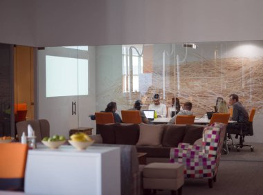 Girişim işi, genç yaratıcı insanlar grup ofis içi toplantılarında beyin fırtınası yapıyorlar ve fikir planları ve projeleri not etmek için dizüstü bilgisayar kullanıyorlar.