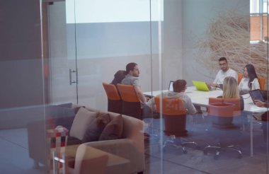 Girişim işi, genç yaratıcı insanlar grup ofis içi toplantılarında beyin fırtınası yapıyorlar ve fikir planları ve projeleri not etmek için dizüstü bilgisayar kullanıyorlar.