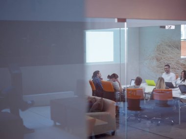 Girişim işi, genç yaratıcı insanlar grup ofis içi toplantılarında beyin fırtınası yapıyorlar ve fikir planları ve projeleri not etmek için dizüstü bilgisayar kullanıyorlar.