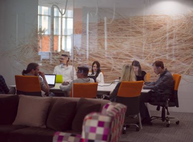 Girişim işi, genç yaratıcı insanlar grup ofis içi toplantılarında beyin fırtınası yapıyorlar ve fikir planları ve projeleri not etmek için dizüstü bilgisayar kullanıyorlar.