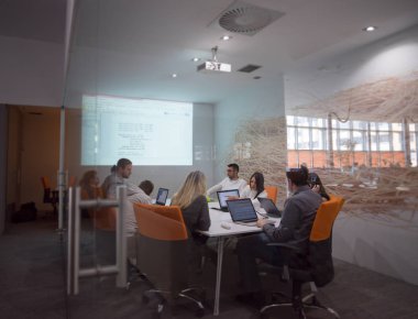Girişim işi, genç yaratıcı insanlar grup ofis içi toplantılarında beyin fırtınası yapıyorlar ve fikir planları ve projeleri not etmek için dizüstü bilgisayar kullanıyorlar.