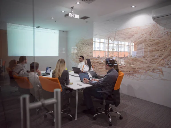 起業家集団がオフィス内で会議をブレインストーミングしたりノートパソコンを使ってアイデアやプロジェクトに注目したり — ストック写真