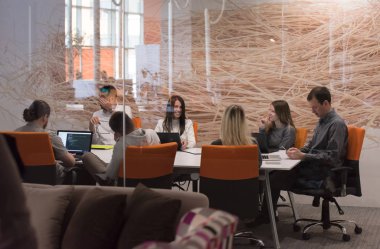 Girişim işi, genç yaratıcı insanlar grup ofis içi toplantılarında beyin fırtınası yapıyorlar ve fikir planları ve projeleri not etmek için dizüstü bilgisayar kullanıyorlar.