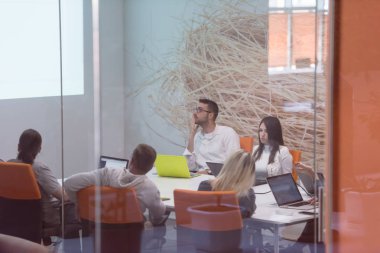 Girişim işi, genç yaratıcı insanlar grup ofis içi toplantılarında beyin fırtınası yapıyorlar ve fikir planları ve projeleri not etmek için dizüstü bilgisayar kullanıyorlar.