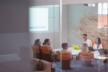 Girişim işi, genç yaratıcı insanlar grup ofis içi toplantılarında beyin fırtınası yapıyorlar ve fikir planları ve projeleri not etmek için dizüstü bilgisayar kullanıyorlar.