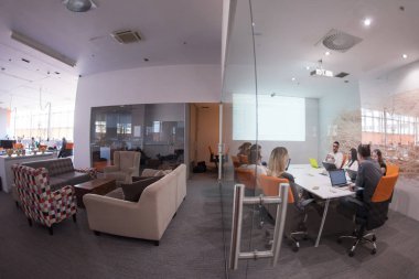 Girişim işi, genç yaratıcı insanlar grup ofis içi toplantılarında beyin fırtınası yapıyorlar ve fikir planları ve projeleri not etmek için dizüstü bilgisayar kullanıyorlar.