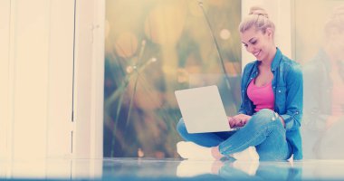 Güzel genç kadınlar lüks evinde dizüstü bilgisayar kullanıyorlar.