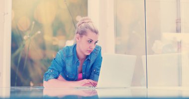 Güzel genç kadınlar lüks evinde dizüstü bilgisayar kullanıyorlar.