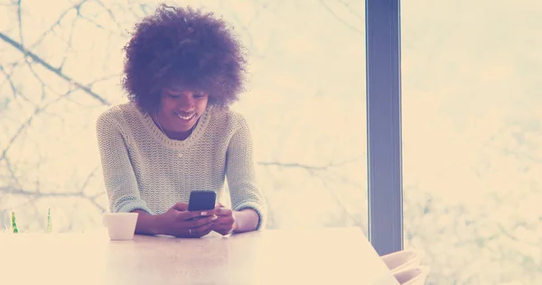 Bonita Jovem Afro Americana Bebendo Café Usando Telefone Celular Casa — Fotografia de Stock