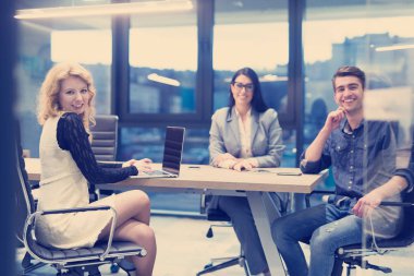 Bir grup genç iş adamı modern ofis binasında iş planlarını tartışıyor