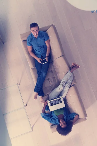 Jong multi-etnische paar ontspant in de woonkamer bovenaanzicht — Stockfoto