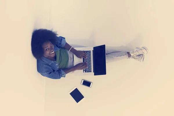 Laptop en iyi manzaralı katta oturan Afrikalı-Amerikalı kadın — Stok fotoğraf