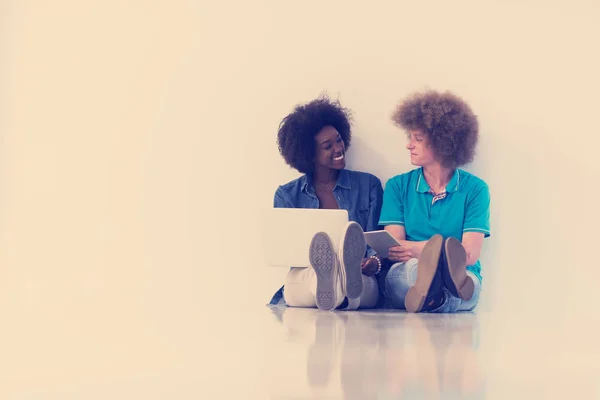 Multiethnisches Paar sitzt mit Laptop und Tablet auf dem Boden — Stockfoto