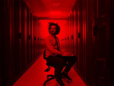 Modern veri merkezindeki sunucu odasında çalışan erkek bilişim mühendisi