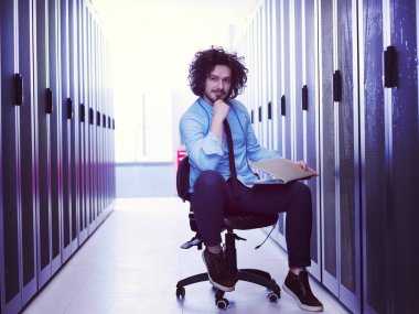 Modern veri merkezindeki sunucu odasında çalışan erkek bilişim mühendisi