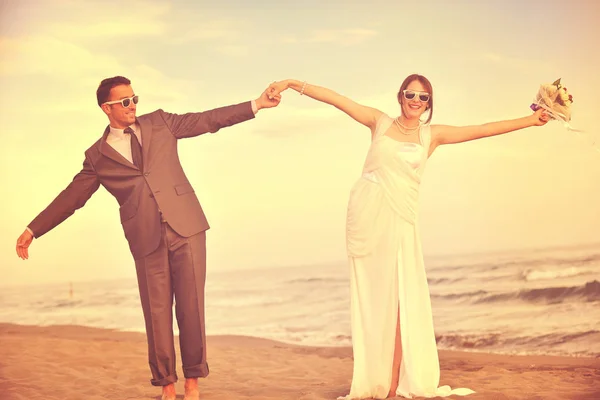 幸せな結婚式のカップルお祝いや美しいビーチの夕日で楽しみます — ストック写真