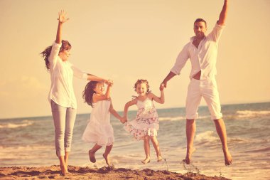 Beyaz elbiseli mutlu genç aile güzel plajlarda tatillerde eğleniyor. 