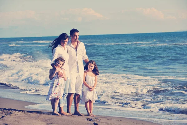 穿着白色衣服的快乐的年轻家庭在美丽的海滩度假时很开心 — 图库照片