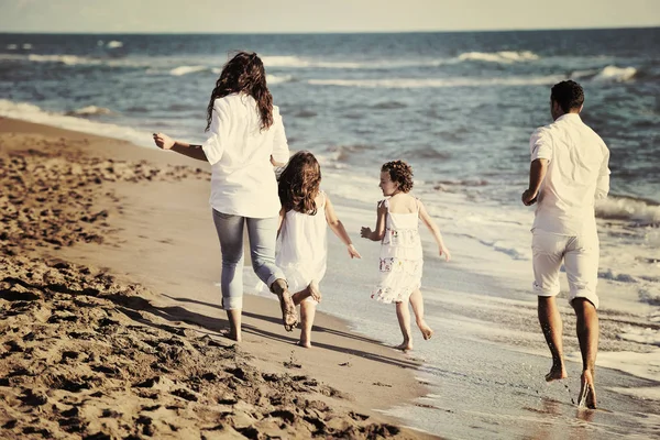白い服の幸せな若い家族は美しいビーチで休暇を楽しんでいます — ストック写真