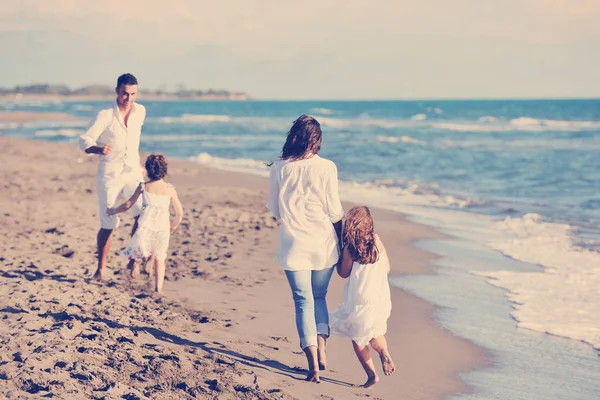 穿着白色衣服的快乐的年轻家庭在美丽的海滩度假时很开心 — 图库照片