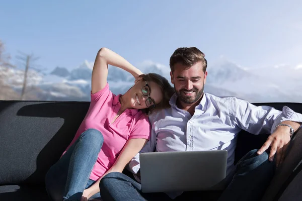 Pareja relajándose en casa usando computadoras portátiles — Foto de Stock