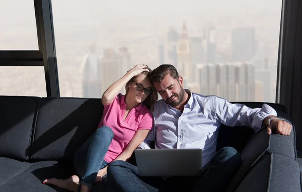 Pareja relajándose en casa usando computadoras portátiles —  Fotos de Stock