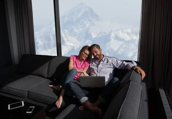 Casal relaxante em casa usando computadores portáteis — Fotografia de Stock