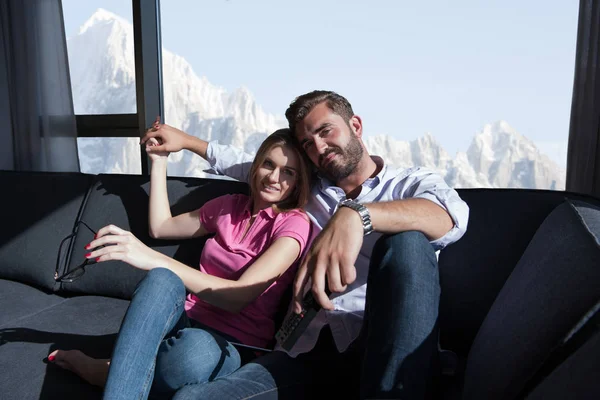 Young couple sitting on sofa — Stock Photo, Image