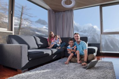 Mutlu bir aile. Baba, anne ve çocuklar video oyunu oynuyorlar. Baba ve oğul yerde oyun oynuyorlar.