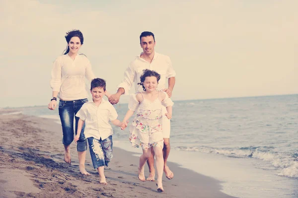 Heureux jeune famille avoir du plaisir sur la plage — Photo