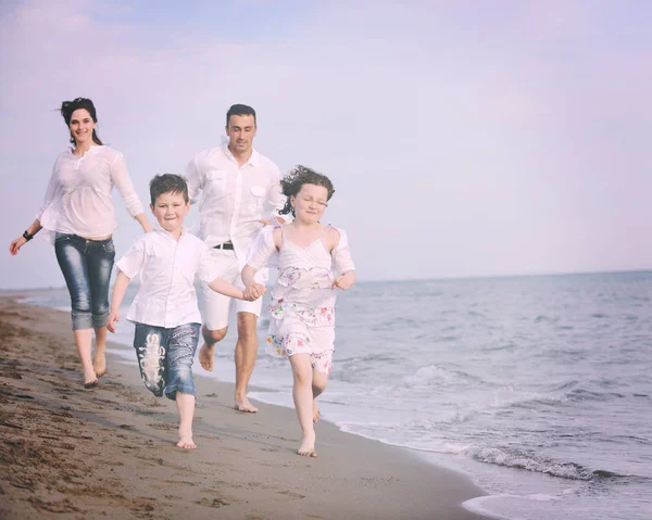 Heureux jeune famille avoir du plaisir sur la plage — Photo