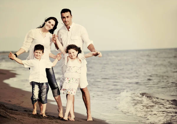 Heureux jeune famille avoir du plaisir sur la plage — Photo