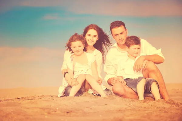 Heureux jeune famille avoir du plaisir sur la plage — Photo