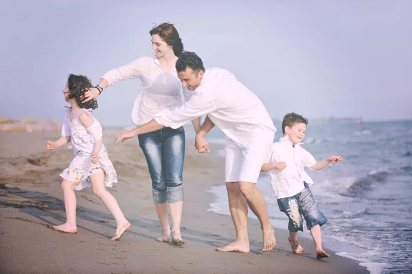 Lycklig ung familj ha kul på stranden — Stockfoto