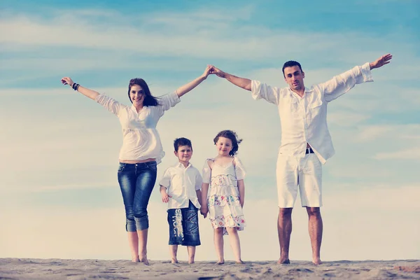 Ευτυχισμένη Νεαρή Οικογένεια Διασκεδάσουν Στην Παραλία Και Δείχνει Σπίτι Σημάδι — Φωτογραφία Αρχείου