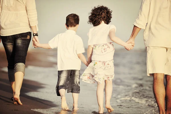 Feliz familia joven divertirse en la playa al atardecer —  Fotos de Stock