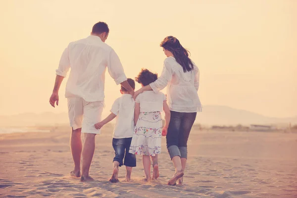 Glückliche junge Familie hat Spaß am Strand bei Sonnenuntergang — Stockfoto