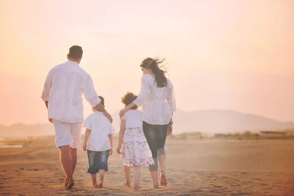 Glückliche junge Familie hat Spaß am Strand bei Sonnenuntergang — Stockfoto