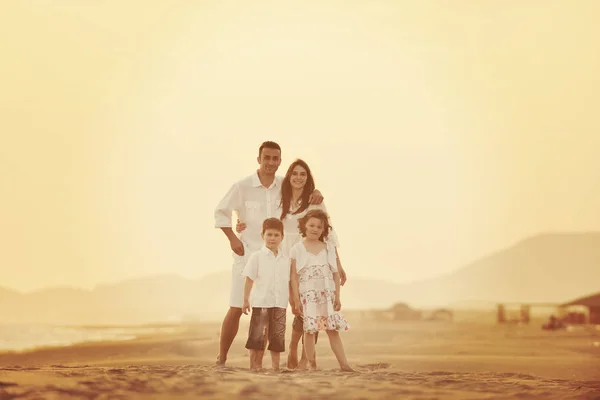 Happy young family have fun on beach at sunset — Stock Photo, Image