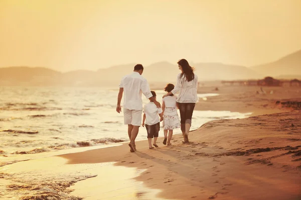 Felice giovane famiglia divertirsi sulla spiaggia al tramonto — Foto Stock