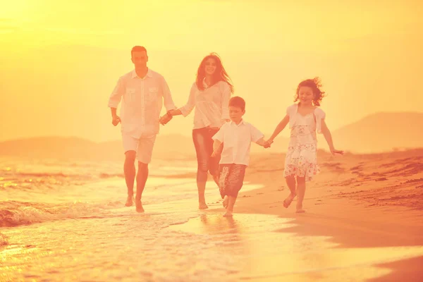 Gelukkig jong gezin veel plezier op het strand bij zonsondergang — Stockfoto