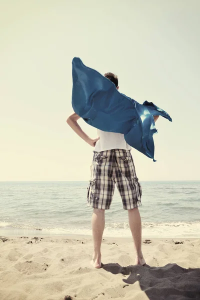 面白いスーパーヒーローは熱い砂の上のビーチに立つ — ストック写真