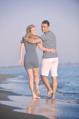 Mutlu genç çift kumsalda romantik vakit geçiriyor.