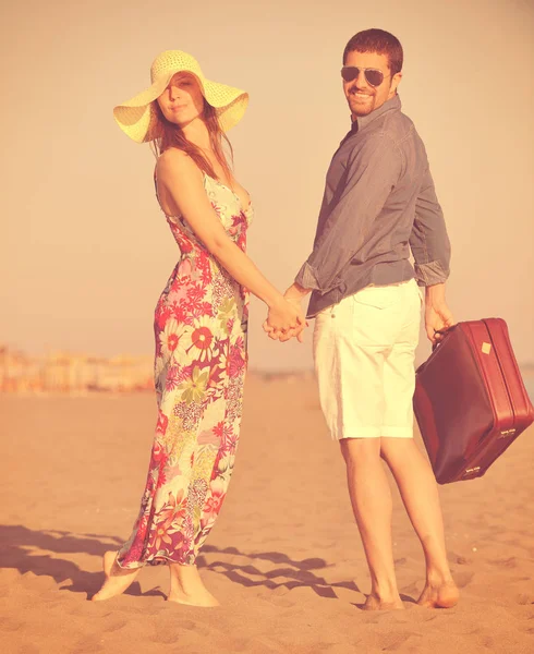 海滩上的一对情侣 带着代表自由和时髦蜜月的旅行袋 — 图库照片