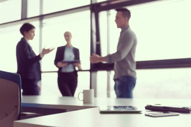Ofis toplantı odasında akıllı telefonu ve tablet bilgisayarı kapat. İş insanları grubu arka planda etkileşim içinde.