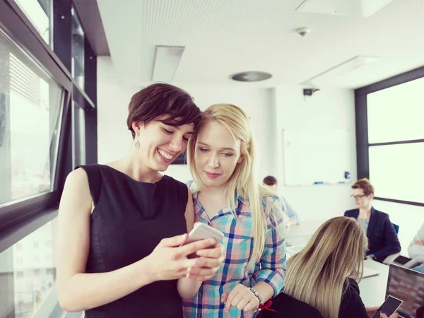 Två Kvinnliga Chefer Som Använder Mobiltelefon Kontorsinteriör — Stockfoto
