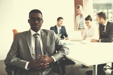 Genç iş adamları, modern ve aydınlık ofiste toplanıp çalışıyorlar.