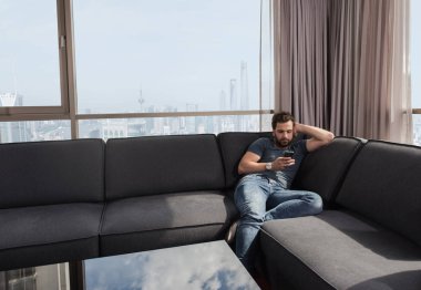 evde bir cep telefonu kullanan genç casual adam